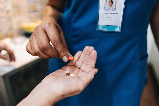 Nurse's hand giving medicine to a patient