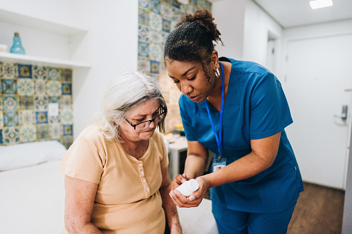 Nurse explaining to senior woman how to take her medicine at home
