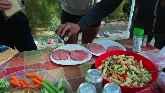 Campers Seasoning Their Burger Patties