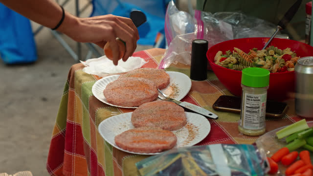 Campers Seasoning Their Burger Patties With Spices