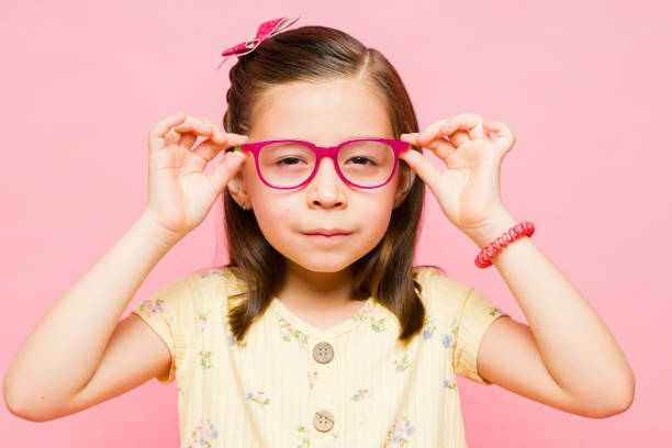 istock Beautiful 7 year old kid putting on her glasses 1629930896