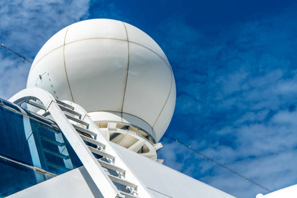 The mast of a large yacht with navigation equipment bottom view. Radar, signal lights, satellite dishes and equipment.