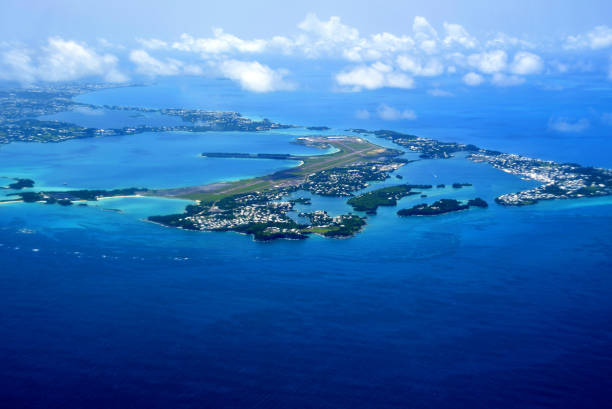 Bermuda from the air - St David's island with the airport and Castle Harbour in the center. Bermuda archipelago: aerial view of Bermuda, the most significant islands are connected by bridges and appear to form one landmass - blue waters of the Atlantic Ocean and from the right the islands of St George, Higgs and Horseshoe, Hen, Peggy, Whalers, Governor, Paget, Smith, Brooks, Oswego, St. David (airport), Nonsuch, Coney, Bermuda, Ireland, Somerset. The archipelago consists of about 360 coral islands, of which only about 20 are inhabited. The island of Grand Bermuda is by far the largest at 39.3 km². The main island is bordered by Somerset Island to the northwest and Saint George's Island to the northeast. Bermuda is a British Overseas Territory. bermuda lagoon stock pictures, royalty-free photos & images
