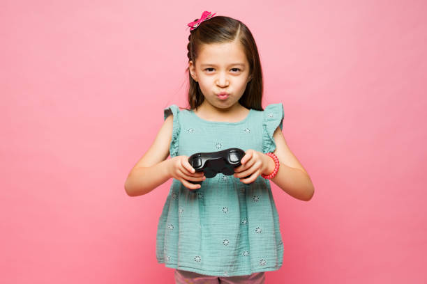 istock Beautiful elementary girl playing videogames 1629959419