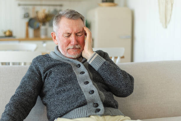 istock Headache pain. Unhappy middle aged senior man suffering from headache sick rubbing temples at home. Mature old senior grandfather touching temples experiencing stress. Man feeling pain hurt in head. 1629971256