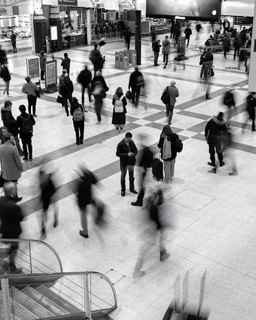 Liverpool Street, United Kingdom – April 14, 2021: A grayscale areal shot of a large group of people walking in an airport