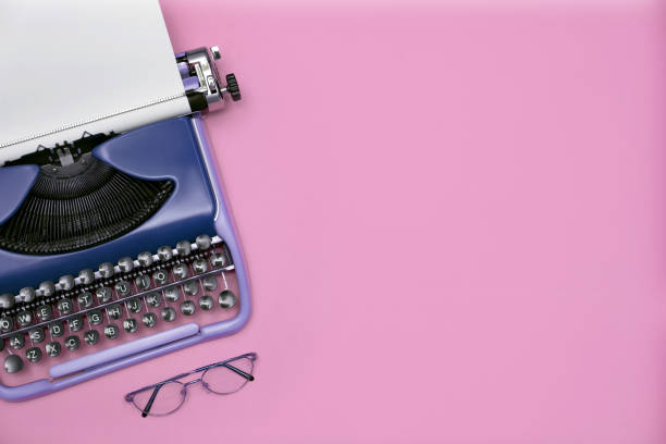 istock Copywriter. Vintage typewriter and eyeglasses on pink background, top view. Space for text 1629978787