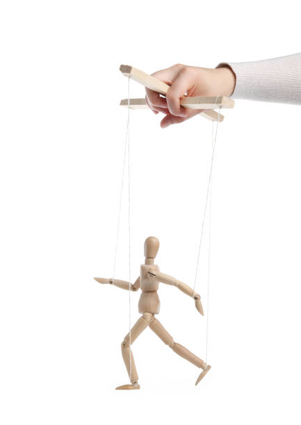 istock Woman pulling strings of puppet on white background, closeup 1629987386