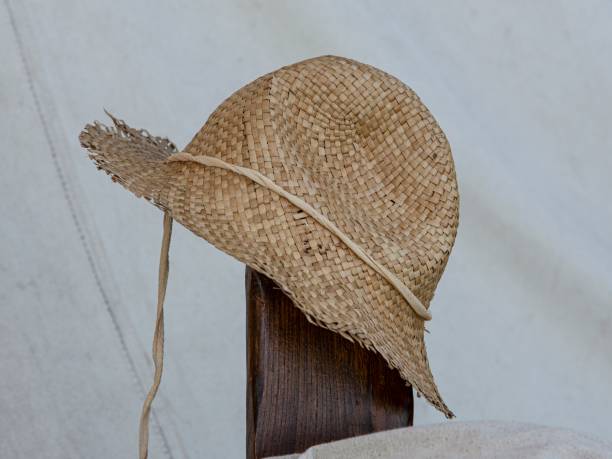 Straw Farmer's Hat On Old Fence Post.