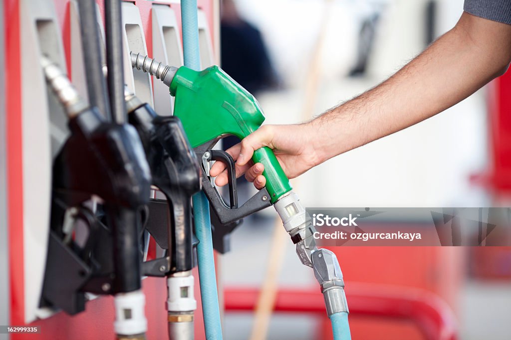 Close-up of person picking up green fuel pump filling up Ethanol Stock Photo
