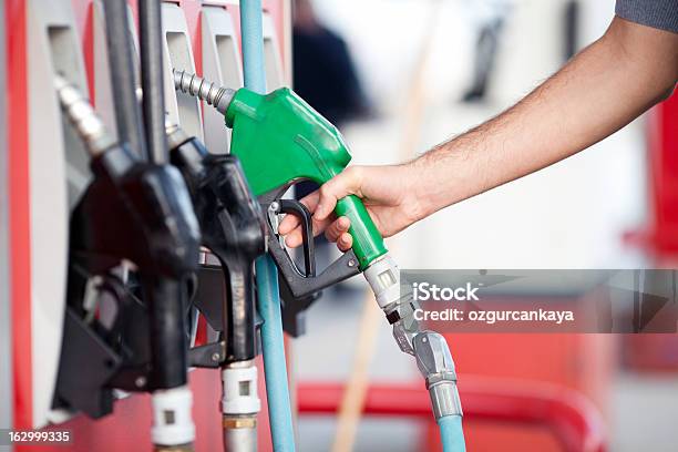 Closeup Of Person Picking Up Green Fuel Pump Stock Photo - Download Image Now - Ethanol, Fossil Fuel, Fuel and Power Generation