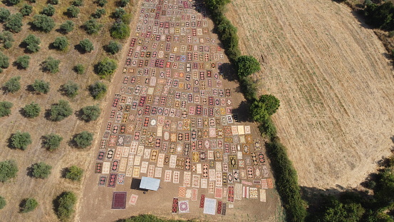 Aerial view of hand-woven carpets laid out on the field for sunbathing
