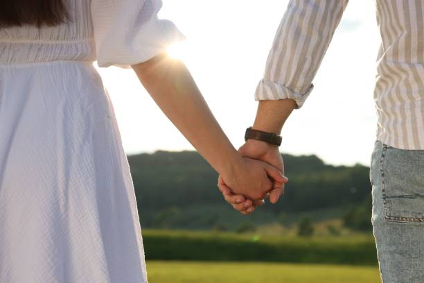 istock Romantic date. Couple holding hands outdoors, closeup 1630036710