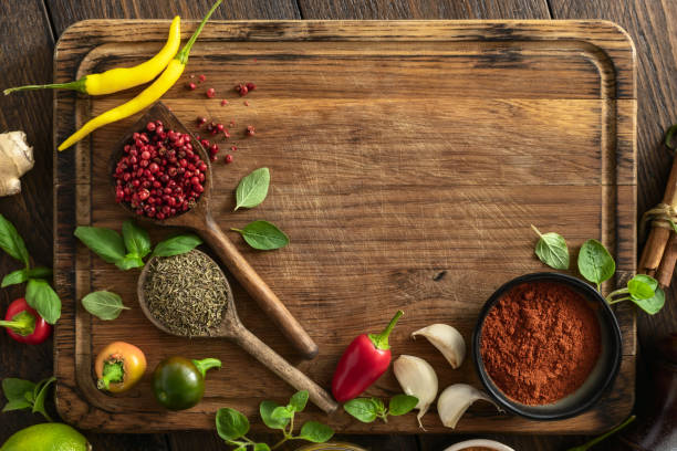 istock Wooden cutting board with various herbs spices and vegetables top view 1630038850