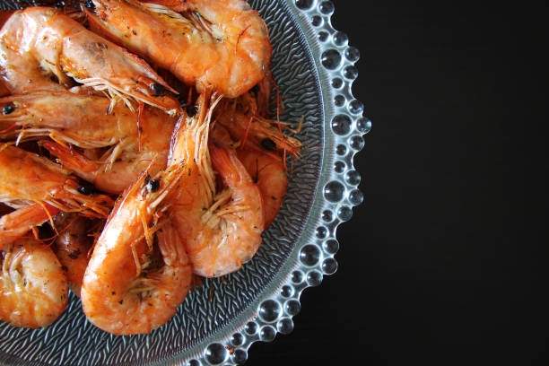 istock Cooked shrimp in a glass bowl on a black background. 1630048744