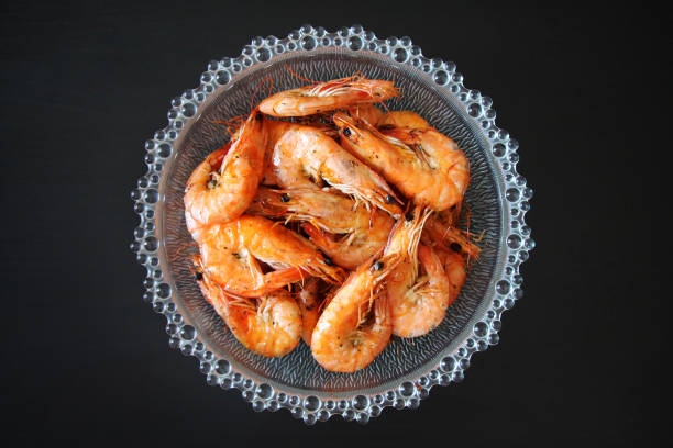 istock Cooked shrimp in a glass bowl on a black background. 1630049264
