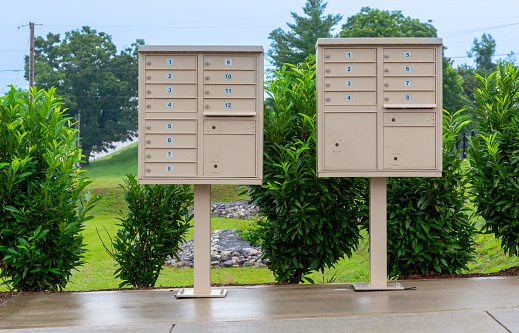 Horizontal shot of two mail boxes holders on stands side by side for a small community.