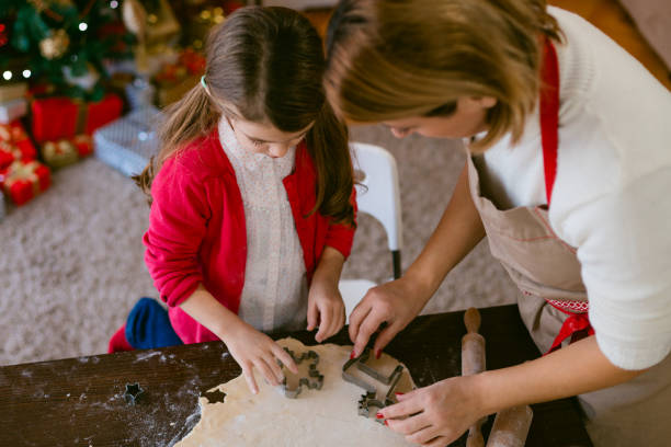 istock Mother and daughter making Christmas cookies with cutting module 1630060498