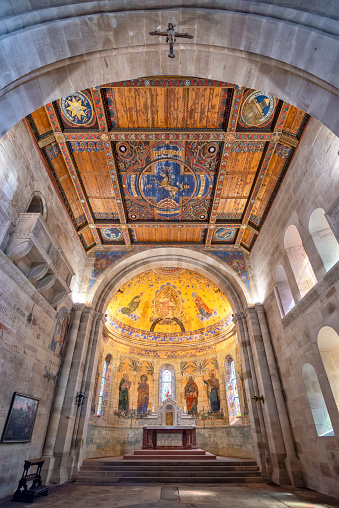 Choir room, wood-paneled church ceiling and altar in the neo-Romanesque 