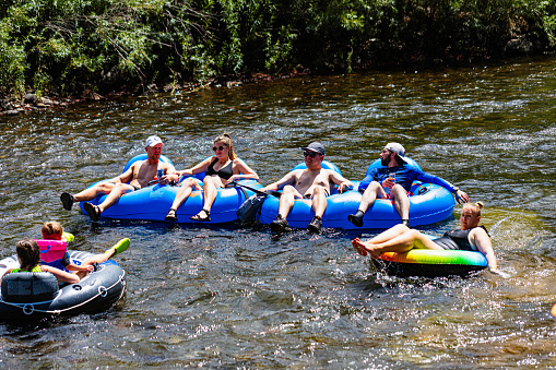 Golden, Colorado, USA,August 12, 2023, group of tubers  floating on Clear Creek
