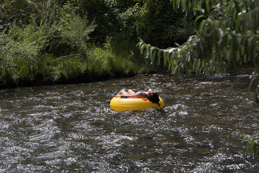 Golden, Colorado, USA, August 12, 2023, female enjoying a peaceful float down Clear Creek