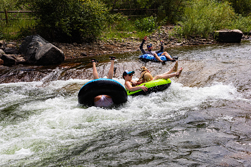 Golden, Colorado, USA, August 12, 2023, three floaters shooting the rapids on Clear Creek