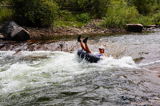 Golden, Colorado, USA, August 12, 2023, female shooting the rapids on Clear Creek with feet in the air