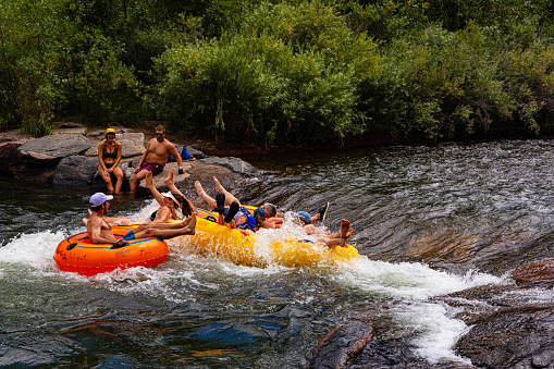 Golden, Colorado, USA, August 12, 2023, group of tubers shooting the rapids on Clear Creek