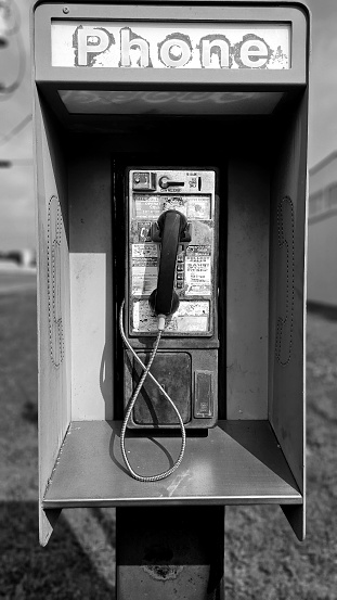 Black and white photograph of public payphone