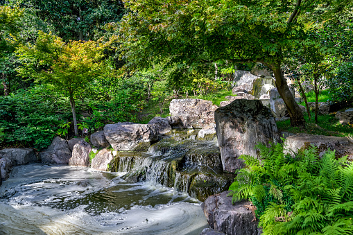 London, England - July 11, 2023: Ornate gardens and decorative statues at a public Kyoto Japanese garden in London's Holland Park