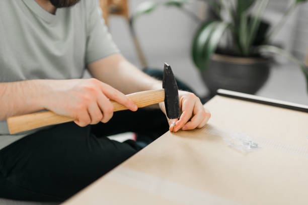 istock Young attractive man assembles furniture - handwerker and interior objects concept 1630094883