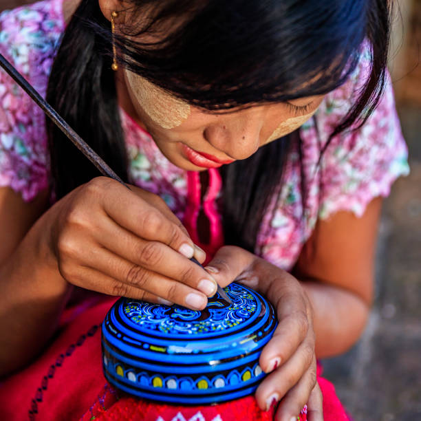 istock Young Burmese girl making a lacquerware in Bagan, Myanmar 1630127448