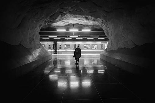a person stands in front of a train at the subway station
