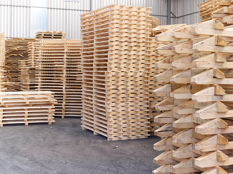 Stack of wooden pallets at the warehouse. Material for industrial cargo freight transport. There are no people.