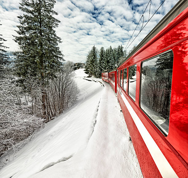 Appenzeller Bahnen red train in beautiful Swiss winter view Focus on reflection on first window. Looking out of tourist train during journey. Train in full speed. Beautiful reflection of landscape on train. With the red train, this picture looks very Swiss. appenzell stock pictures, royalty-free photos & images