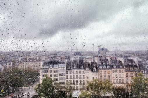 City in the rain, seen through a window (Paris, France). Unidentifiable people.