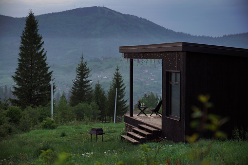 Modern black cabin with terrace on Carpathian mountains in Ukraine
