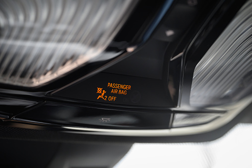 Front passenger airbag deactivation indicator light in a modern car.
