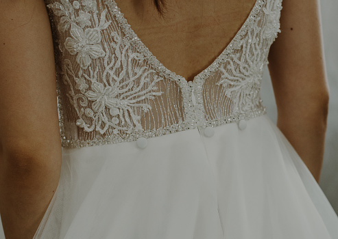 Beautiful view of the lace wedding dress on the bare back of the bride,close up side view.