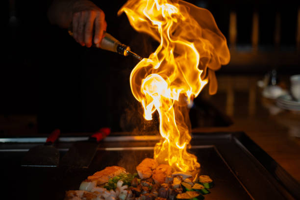 chef cocinando en el restaurante japonés teppanyaki - teppan yaki fotografías e imágenes de stock