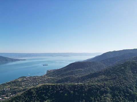 aerial view in nature, with mountains, forest, clear sky, view of the ocean with an oil tanker