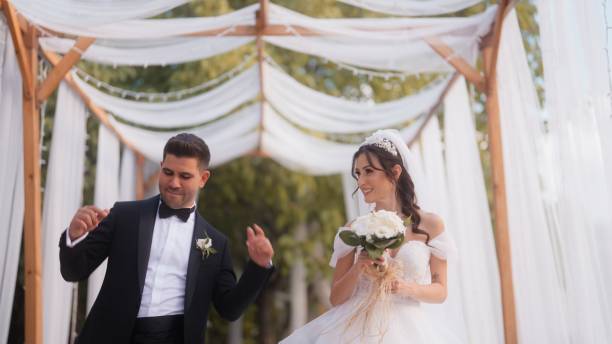 istock Bride and groom walking and dancing together 1630308017