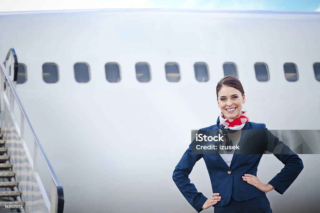 Beautiful air stewardess Outdoor portrait of a beautiful flight attendant standing in front of an aircraft and smiling at the camera. Air Stewardess Stock Photo