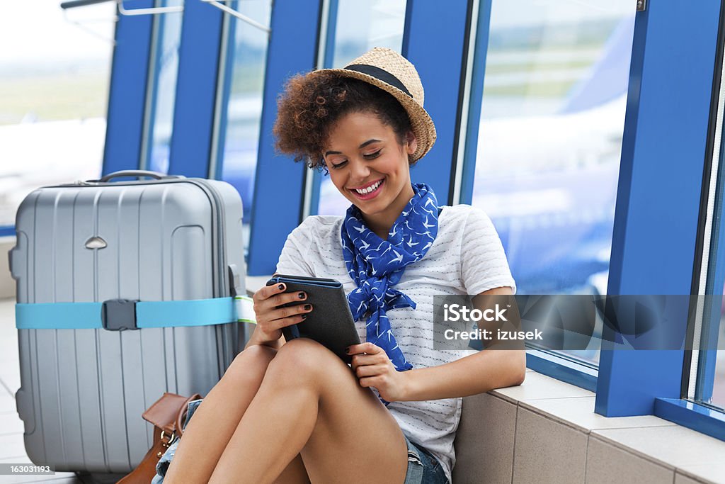 Waiting for the flight Portrait of teenaged girl waiting for her flight at the airport and reading e-book. Travel Stock Photo