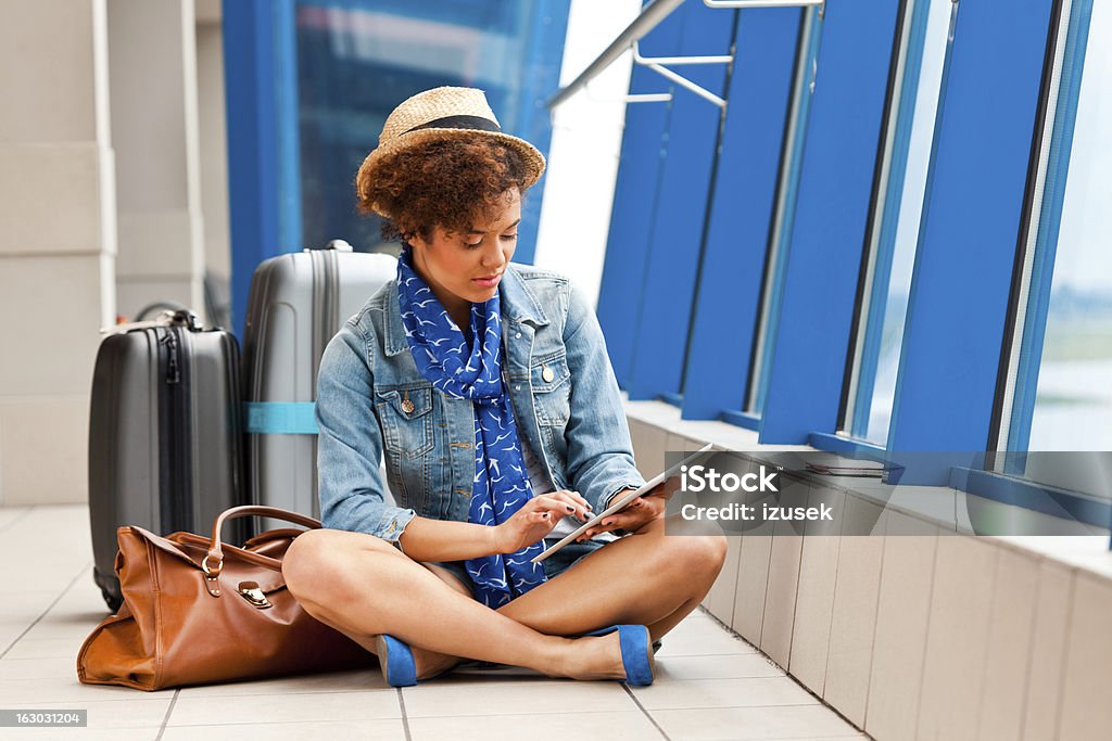 Cute girl with a digital tablet at the airport A teenaged girl waiting for her flight at the airport and using a digital tablet. 18-19 Years Stock Photo