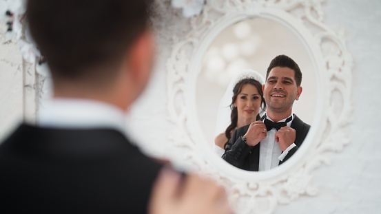 A portrait of a newlywed couple through a mirror.