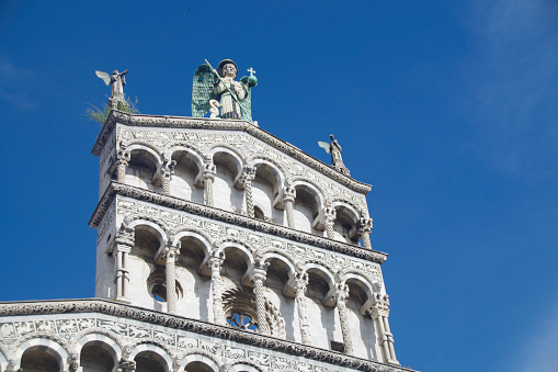 Close-up of St. Michael the Archangel and the facade of Chiesa di San Michele in Foro, Lucca, Italy