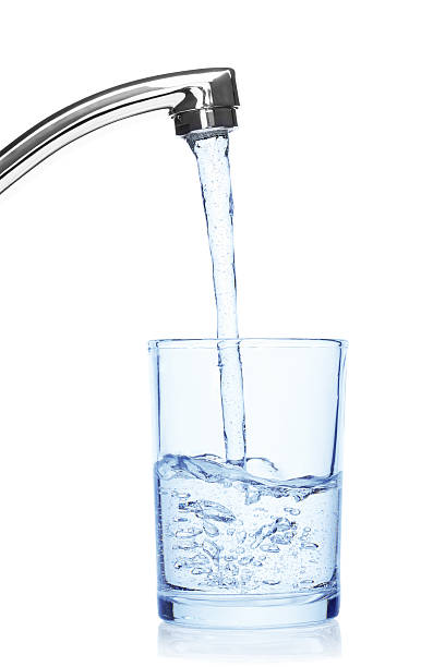 стекло с питьевой водой из ответвитель. - faucet стоковые фото и изображения
