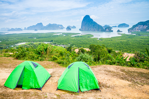 Camping tent on top of mountain with beautiful sea island view and forest seaside, Samet Nangshe Phang-nga Thailand. Summer tropical holiday vacation and lifestyle concept.