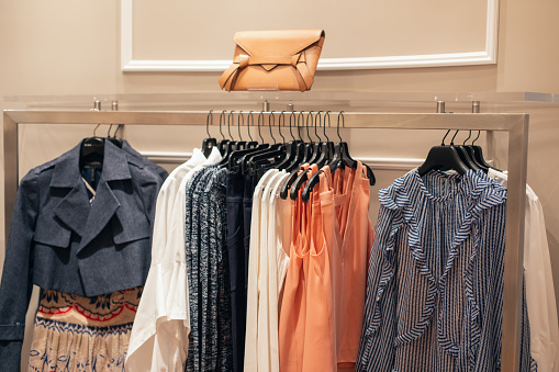 Clothing on hanger at the modern shop boutique. Female clothes hanged at store